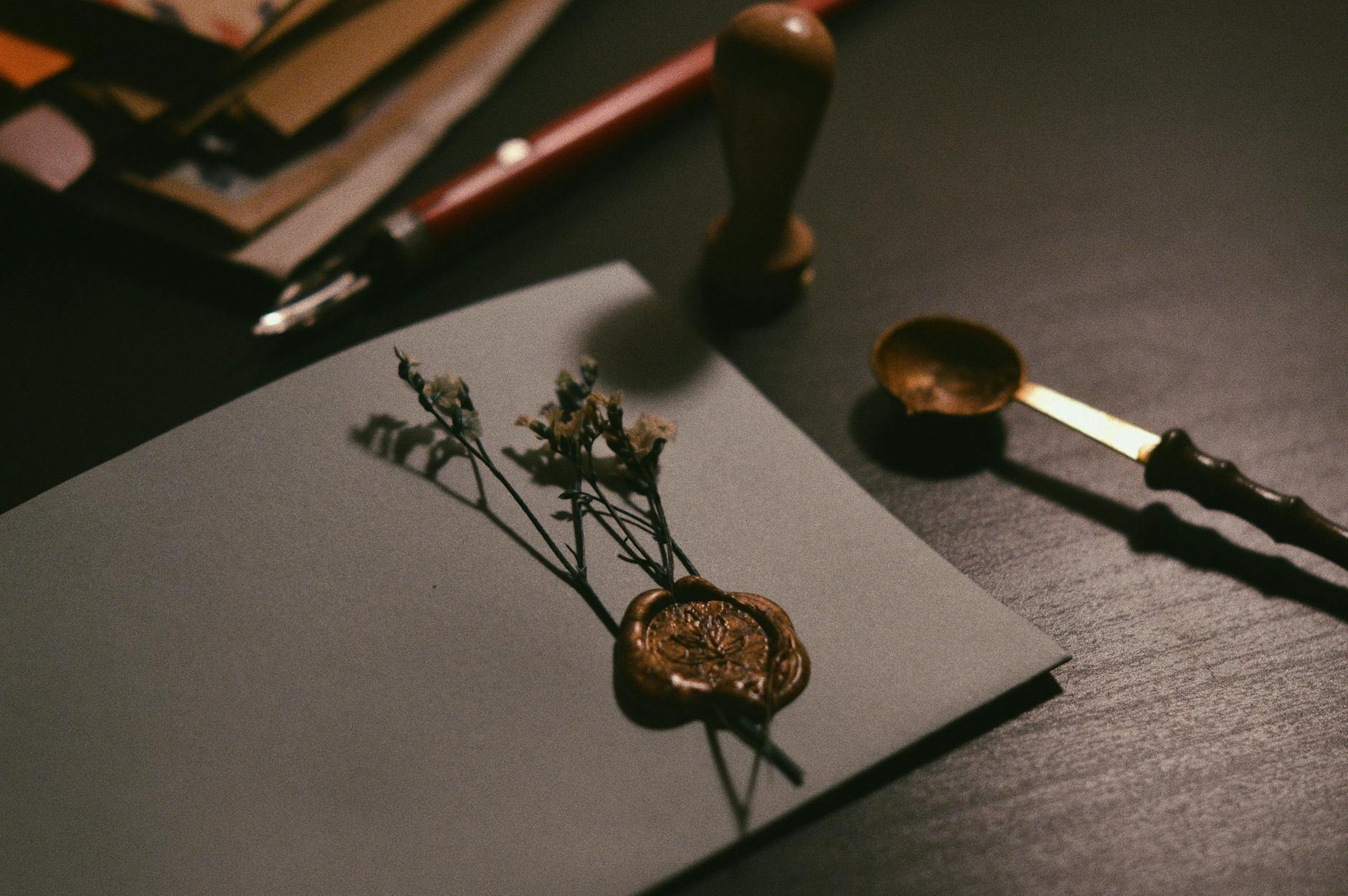 An appraiser's hand holding an antique magnifying glass over a faded red hanko seal on a Japanese scroll painting, assessing the authenticity of the cinnabar ink. - Antique identification guide